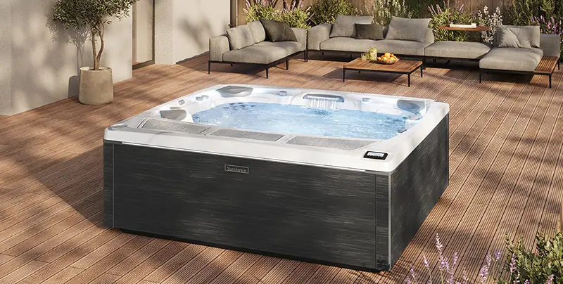 Sundance Spas 980 Series hot tub in a modern outdoor patio setting