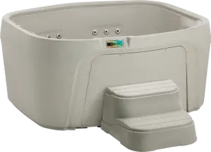 Front view of the Fantasy Spas Drift hot tub in Sand finish with black cover removed, showing four contoured seats and stainless steel jets.