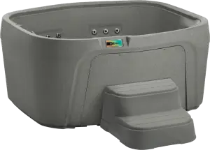 Front view of the Fantasy Spas Drift hot tub in Taupe finish, showing four contoured seats, waterfall feature, and stainless steel jets.