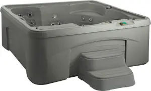 Front view of the Fantasy Spas Entice hot tub in Taupe finish, showing lounge seat, waterfall feature, and 27 stainless steel jets.