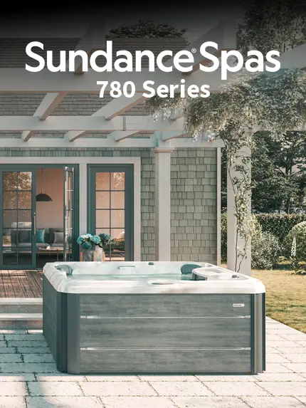 Sundance Spas 780 Series hot tub on a shaded patio outside a modern home.