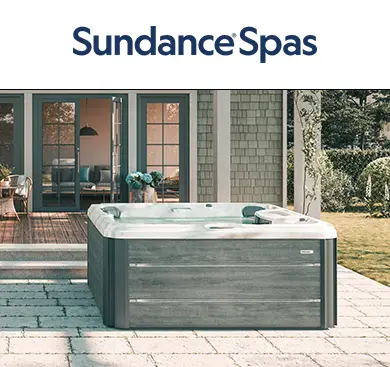 Sundance Spa installed on a sunlit backyard patio outside a modern home